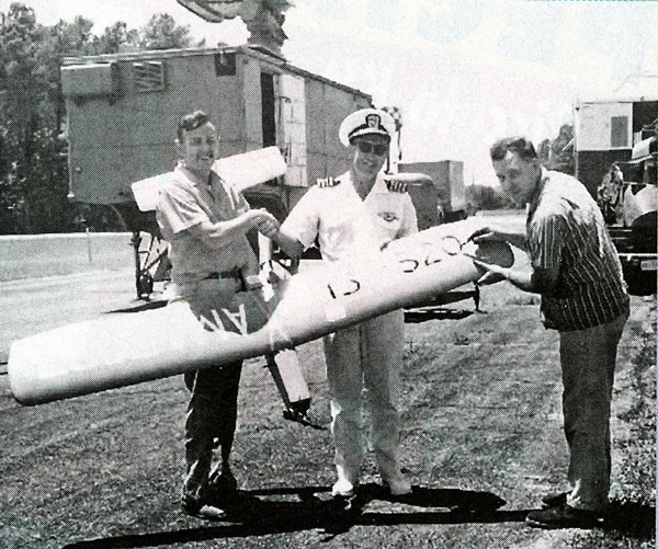 Circa 1963. Captain W.A. Sellers, commanding officer of Dahlgren Naval Surface Laboratory, congratulates Maynard (L) on his first world record. John Worth, then AMA president, inscribes altitude achieved. Fremont Davis photo.